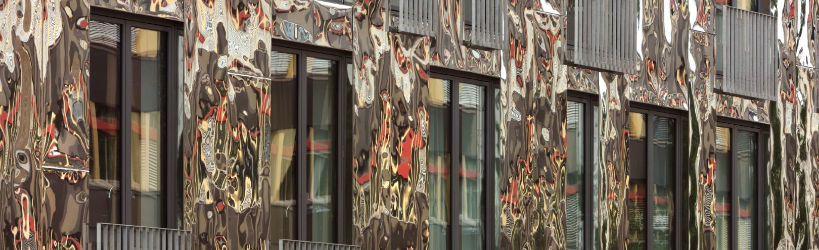 H6 in Berlin mit spiegelnder Fassade aus ROOFINOX CHROMA Fassadenschindeln